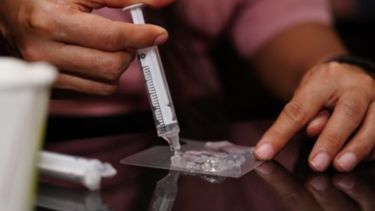 A person testing materials with a pipette.